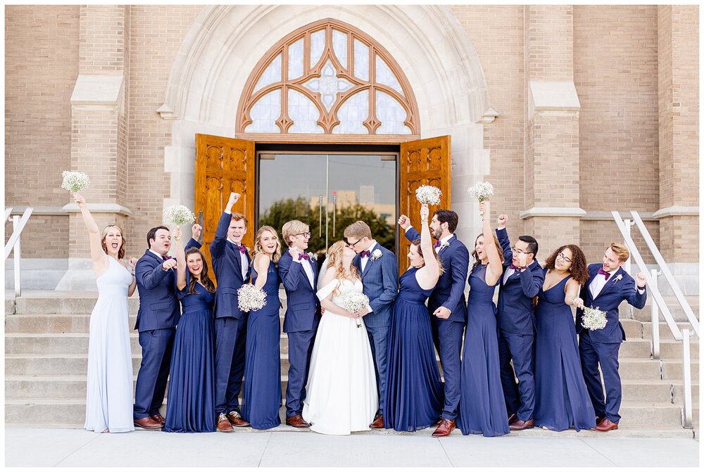 A Holy Family Cathedral Wedding party cheering for the bride and groom.