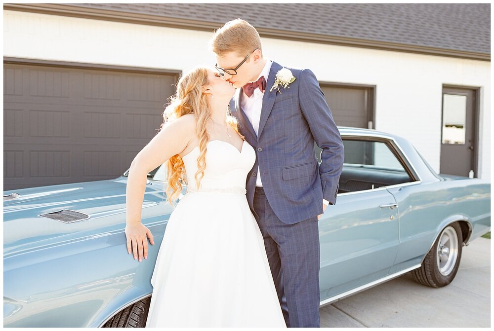Bailey and Logan in front of a vintage car after A Holy Family Cathedral Wedding.
