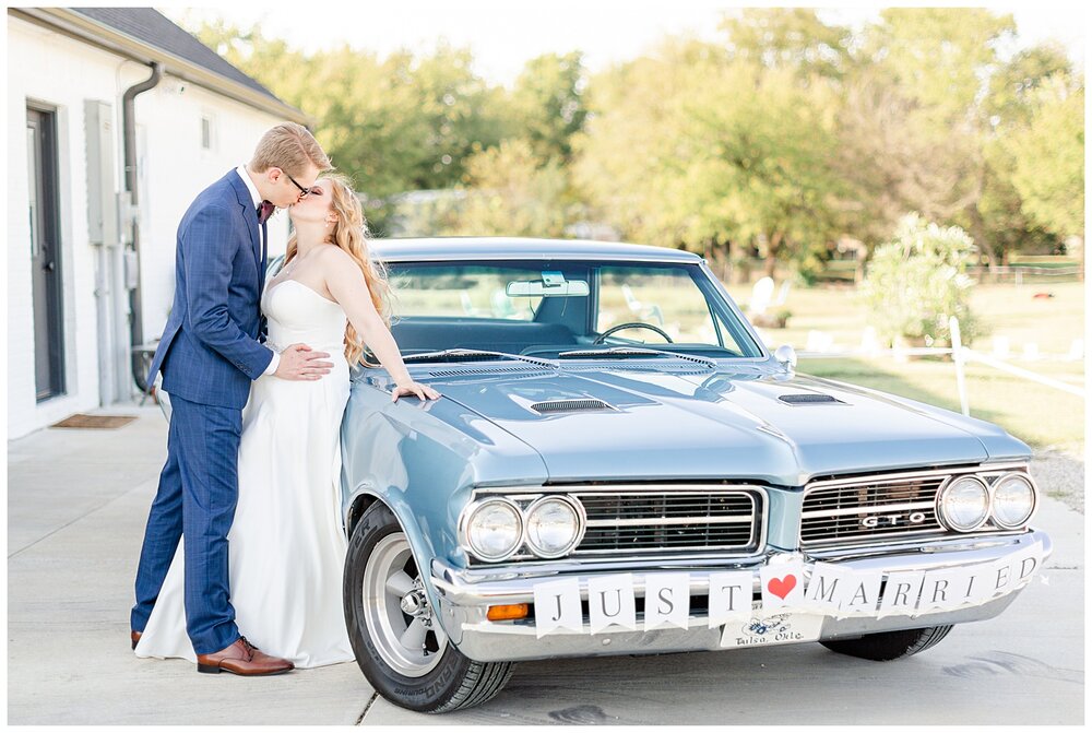 Bride and groom standing with their vintage getaway car after A Holy Family Cathedral Wedding.