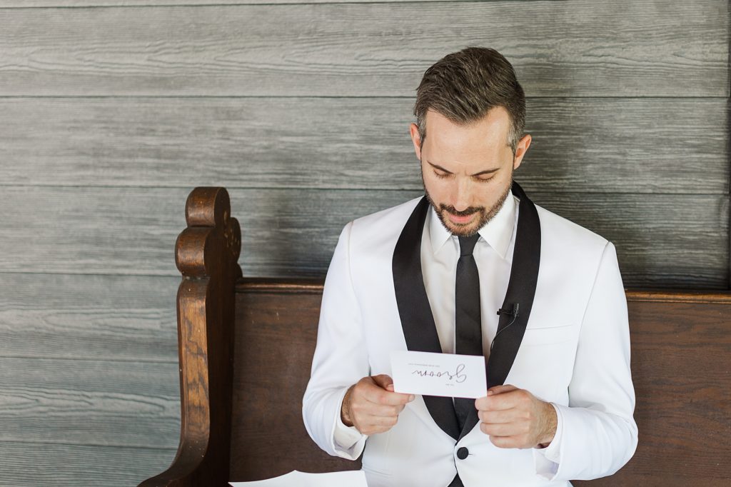 Groom reading a letter on his wedding day at Pecandarosa Ranch.