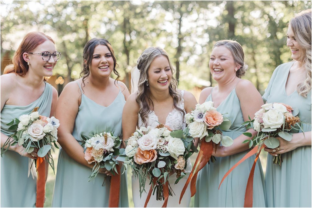 Bridesmaids giggling in their soft blue dresses after the wedding.