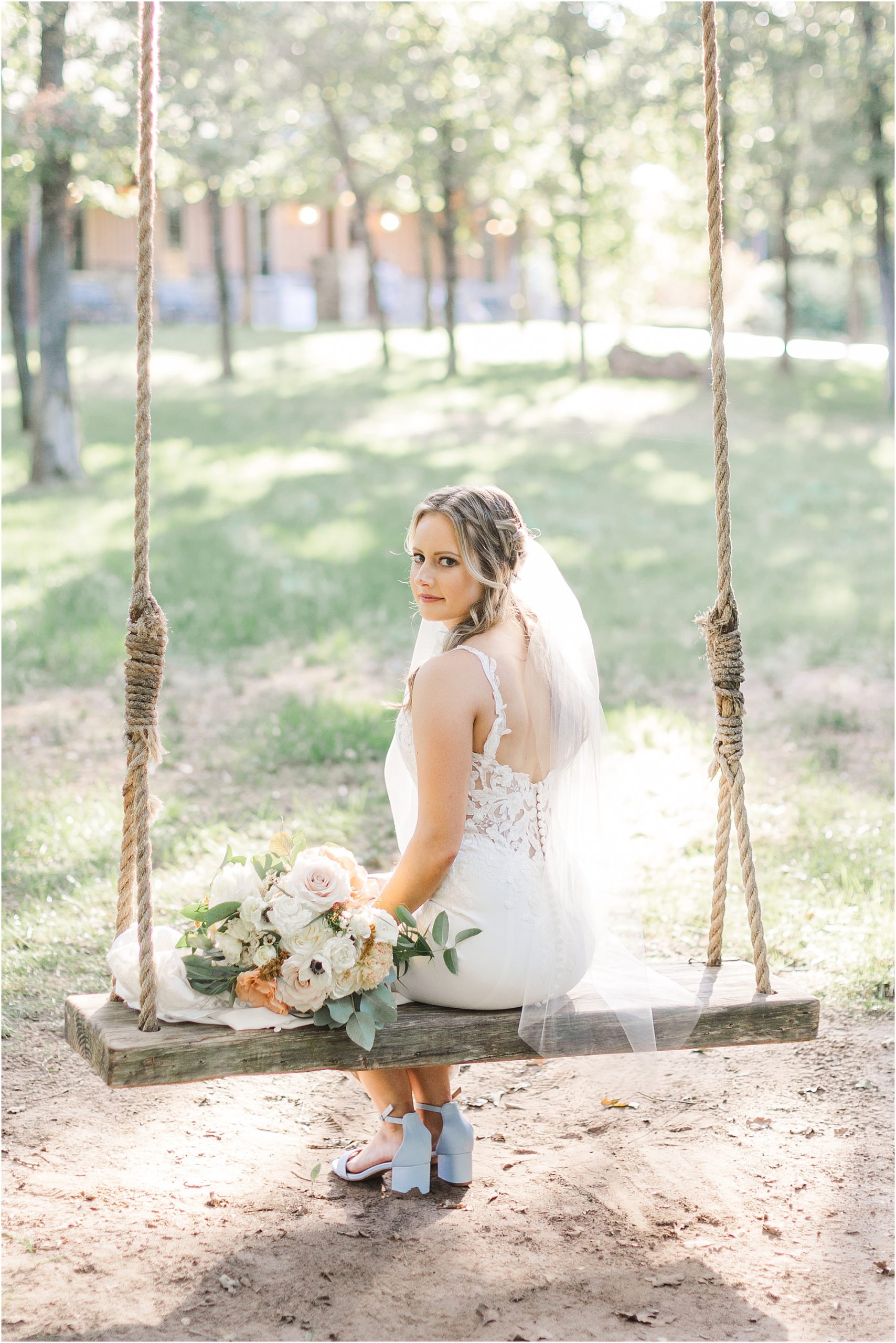 The bride swinging in the woods on her wedding day.