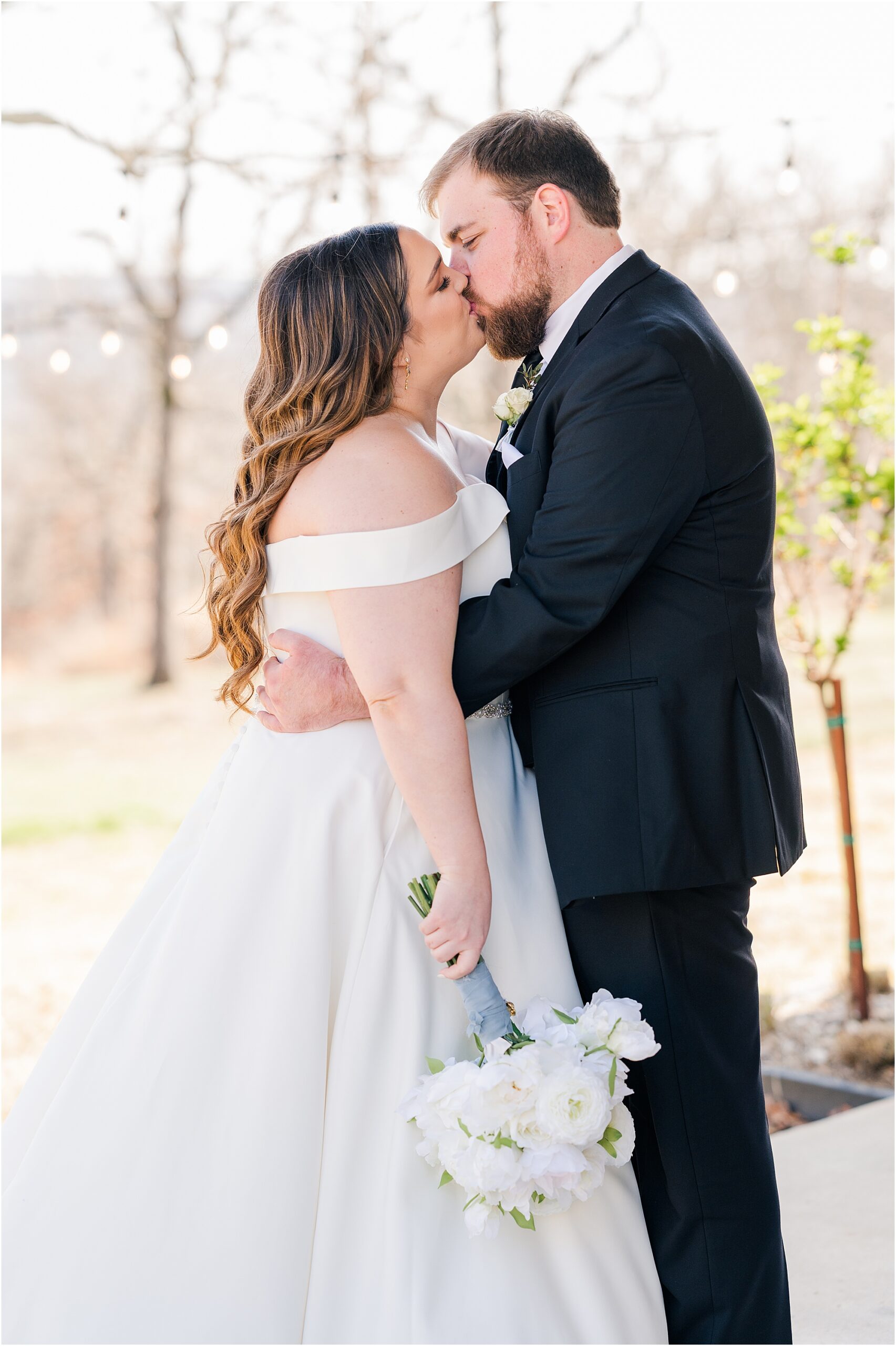 The bride and groom sharing a kiss before their ceremony at their Dream Point Ranch Wedding.