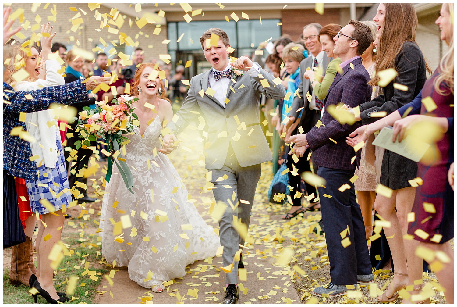 Bride and groom walking through confetti at their rainy spring wedding.