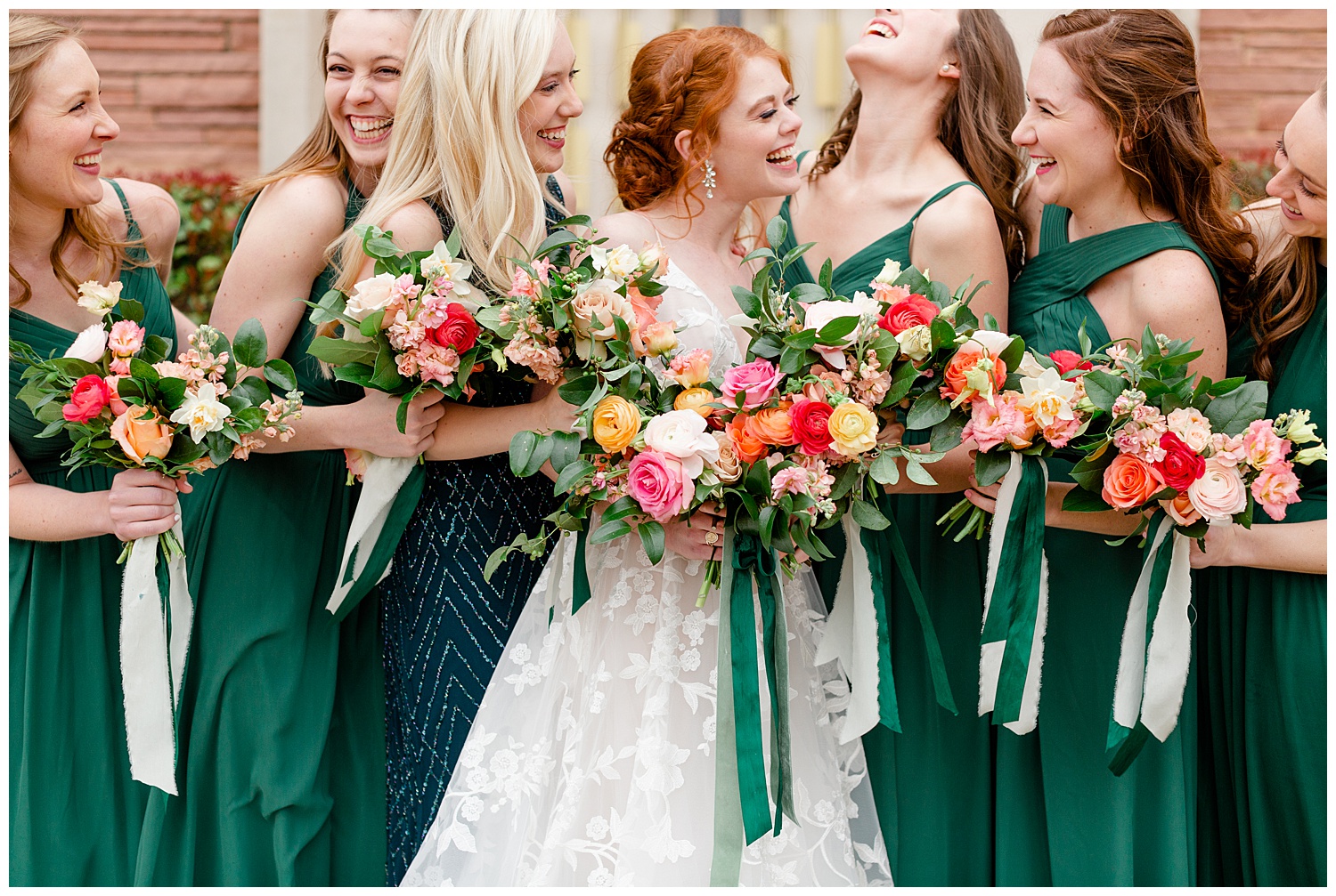 Bride and bridesmaids in emerald green dresses on a rainy wedding day.