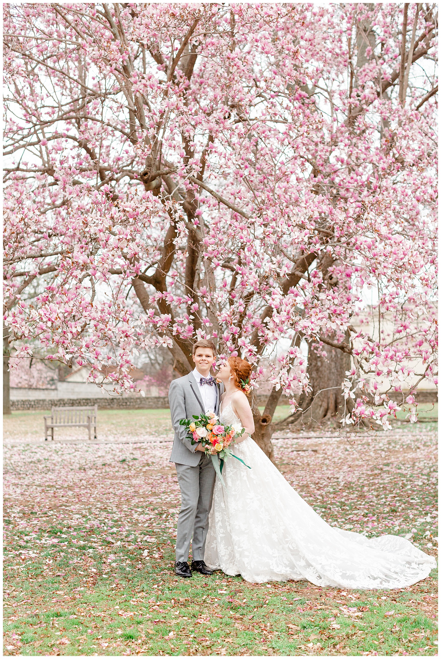 Bride and groom standing under the cherry blossom tree in the rain.