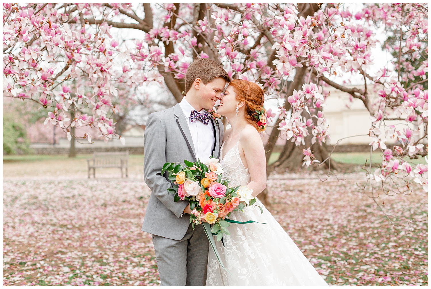 Ashley and Grant sharing a kiss under the cherry blossoms in the rain on their wedding day.
