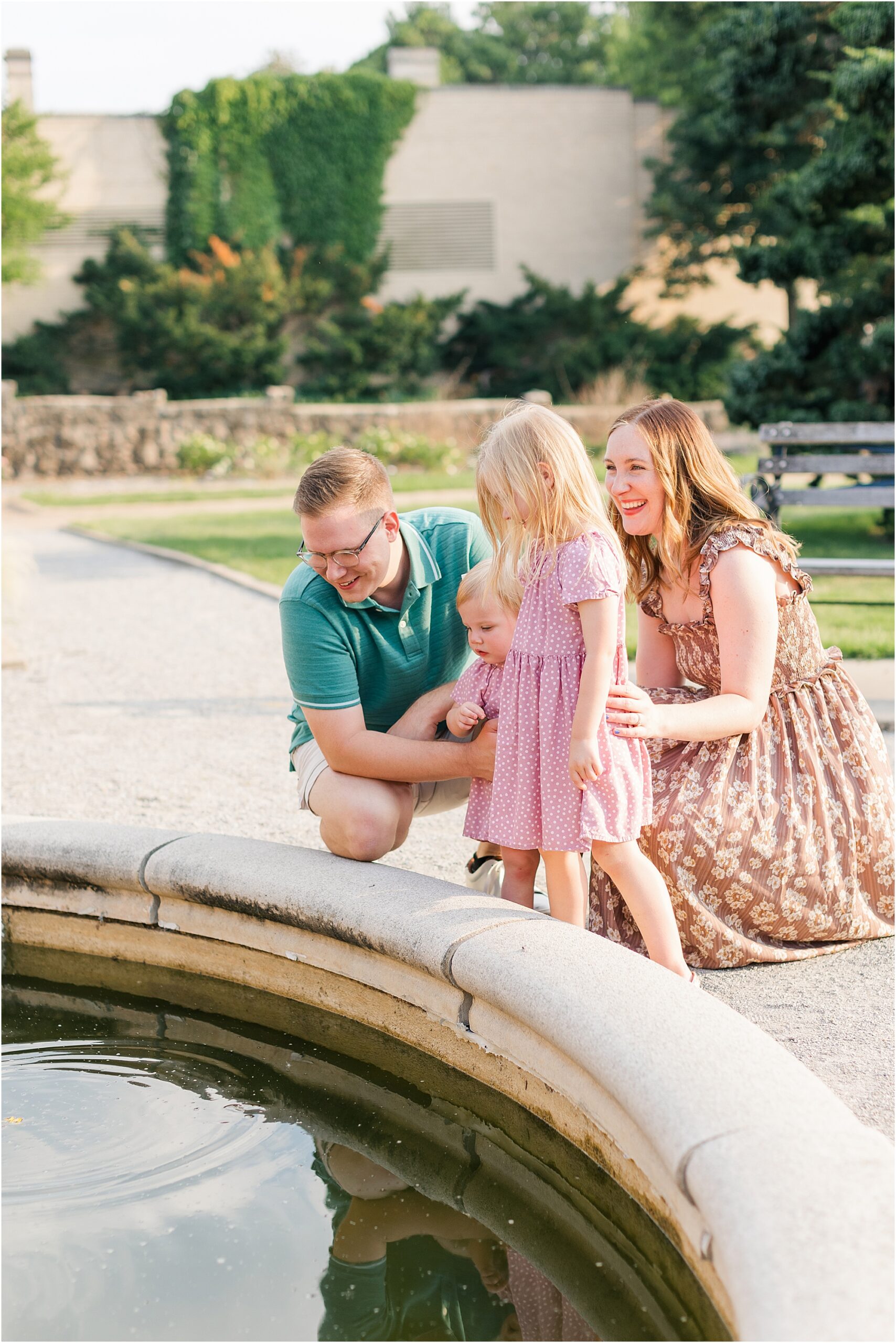 A family throwing flower petals in the coy pond at their summer family photo session.