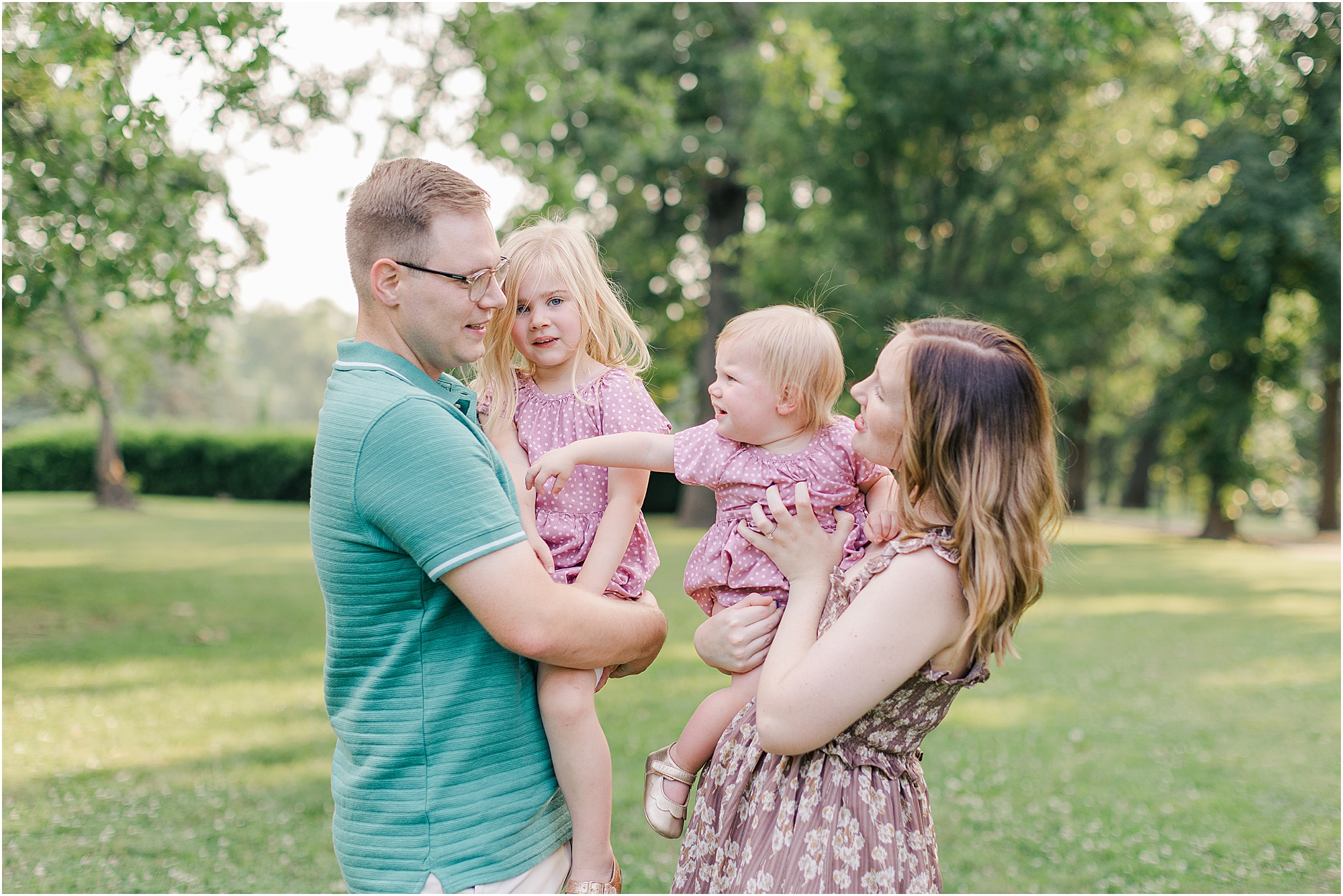 A family of four in the park at their summer family photo session.