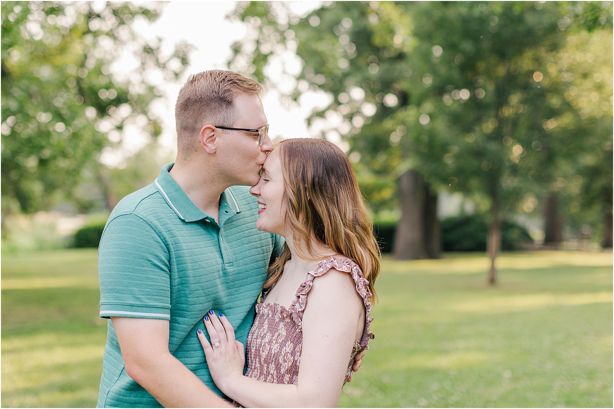 Mom and dad sharing a kiss at woodward park during their summer family photo session.