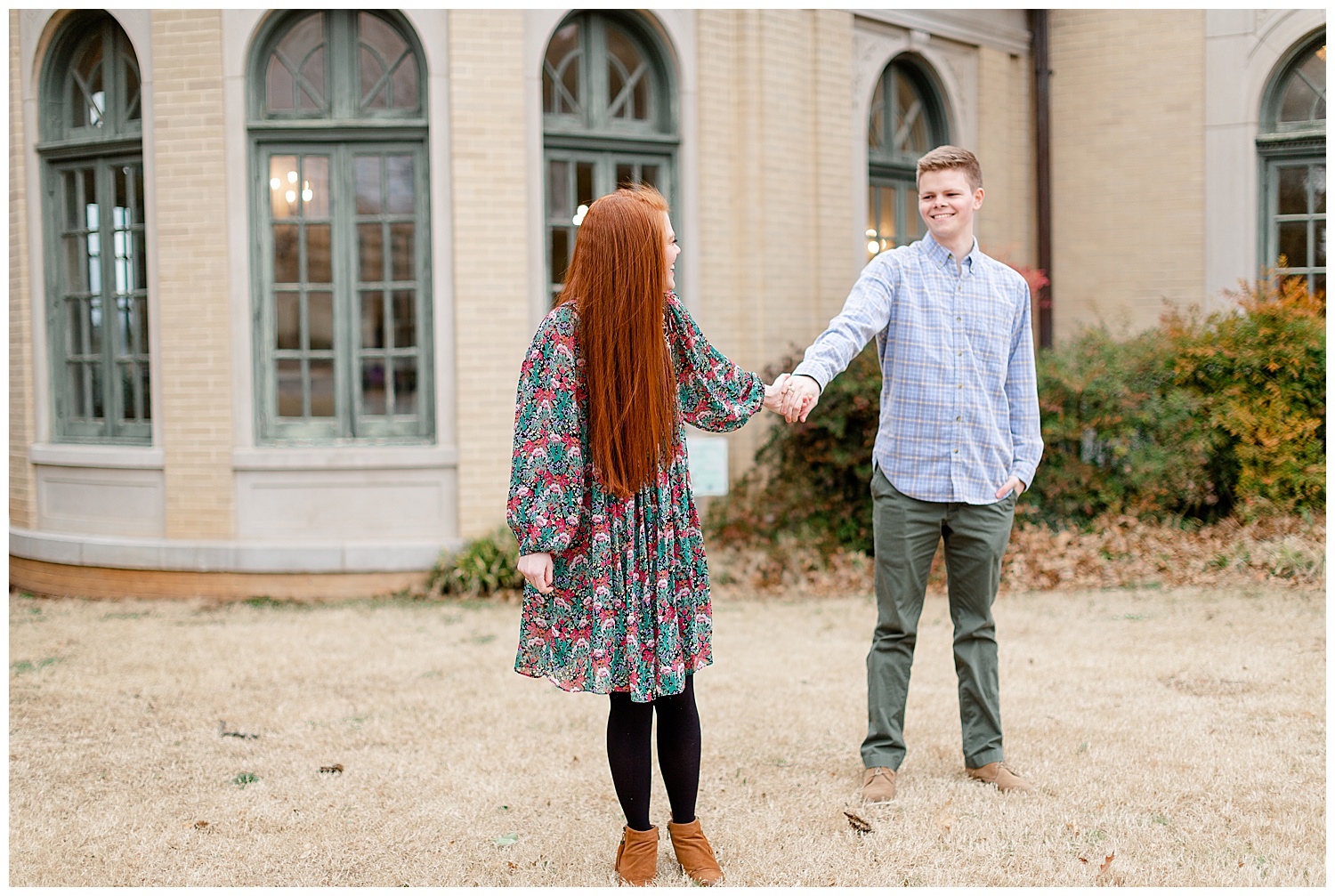 grant and ashley holding hands during their spring engagement session in front of the mansion at woodward park.