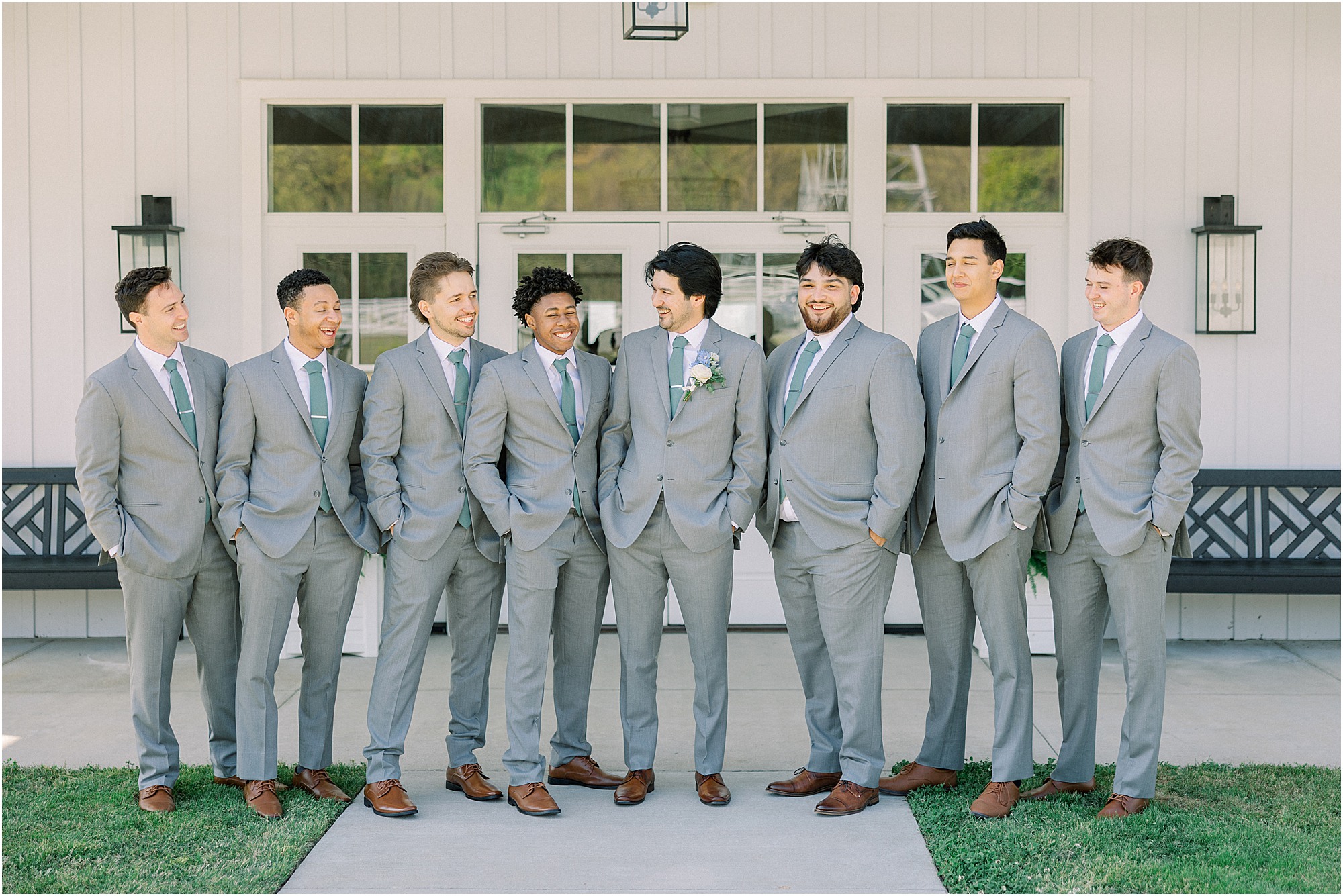 Groomsmen in front of Lakeview Hills wedding venue on a glowy Spring day. 